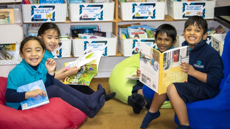 Primary school students reading outside